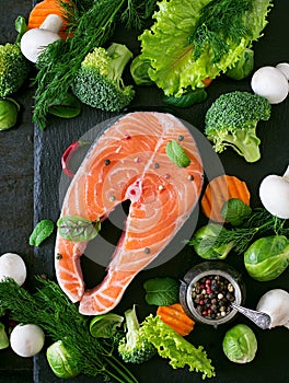 Raw salmon steak and ingredients for cooking.