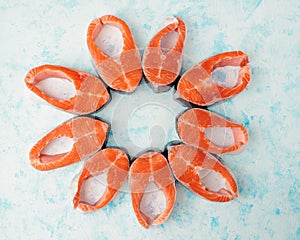 Raw salmon steaks pattern on a blue background top view