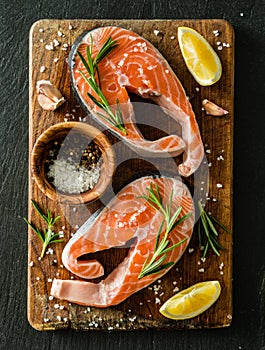 Raw salmon steaks on rustic background