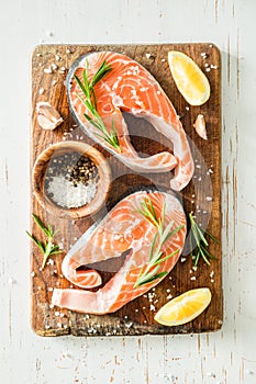 Raw salmon steaks on rustic background