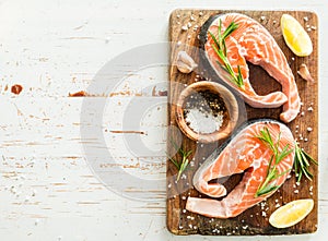 Raw salmon steaks on rustic background