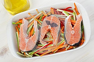 Raw salmon steaks with vegetables