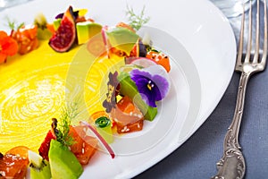 Raw salmon tartare with fruits, vegetables, flowers