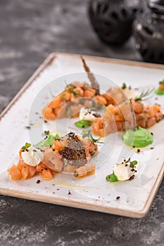 Raw salmon tartare steak with wasabi on the table