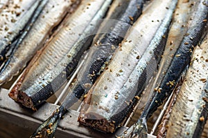 Raw saury on a grill for smoking with lemon and herbs top view