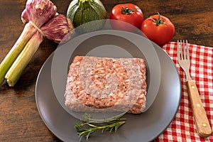 Raw sausage meat with fresh vegetables