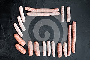 Raw sausages, frame concept, top view with space for text, on black background