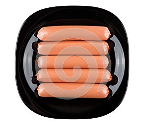 Raw sausages in polyethylene shell in black plate on white