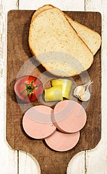 Raw scalded sausage on a wooden board