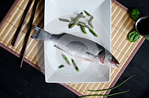 Raw sea bass white plate flatlay