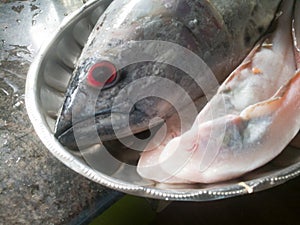 Raw Sea fish with red eyes in a steel plate Kerala specials.