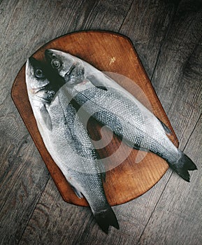 Raw seabass fish on the wooden board