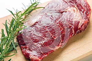 Raw seasoned beef slice on a wooden board