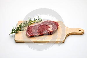 Raw seasoned beef slice on a wooden board