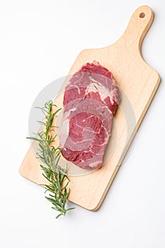 Raw seasoned beef slice on a wooden board