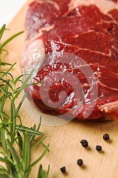 Raw seasoned beef slice on a wooden board