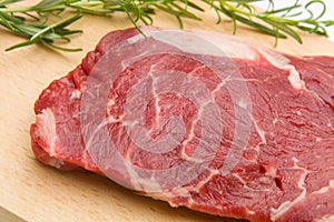 Raw seasoned beef slice on a wooden board