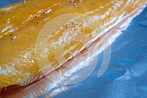 Raw seasoned fish fillets on baking tray closeup