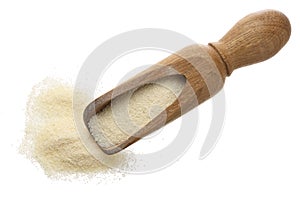 Raw semolina in wooden scoop isolated on white background. Top view