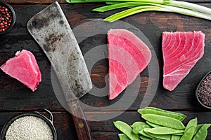 Raw sesame tuna steak ingredients, and old butcher cleaver knife, on old dark  wooden table background, top view flat lay