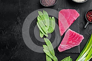 Raw sesame tuna steak ingredients, on stone board, on black stone background, top view flat lay , with copyspace  and space for