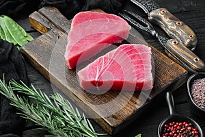 Raw sesame tuna steak ingredients, on wooden cutting board, on black wooden background