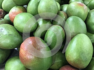 The raw shiney green mango in the stall photo