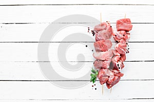 Raw shish kebab. barbecue Meat with spices and herbs. On a white wooden background.