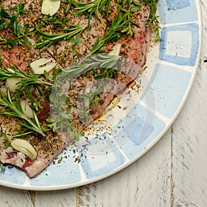 Raw Shoulder of Lamb Meat in Olive Oil Marinade on Plate With Bl