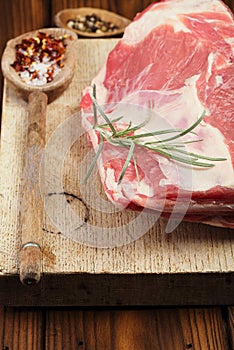 Raw shoulder lamb on wooden board and table