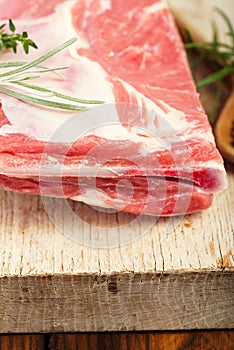 Raw shoulder lamb on wooden board and table