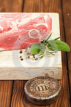 Raw shoulder lamb on wooden board and table photo