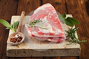 Raw shoulder lamb on wooden board and table photo