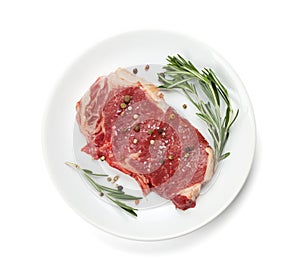 Raw sirloin steak with rosemary and spices on plate