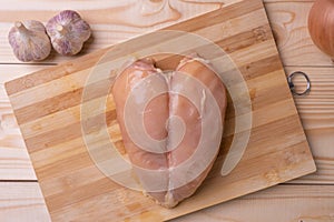 Raw skinless chicken breast on a cutting board