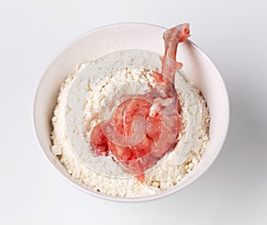 Raw skinless chicken drumstick in flour