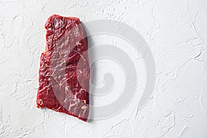 Raw skirt or flank steak,on a white stone background top view space for text photo