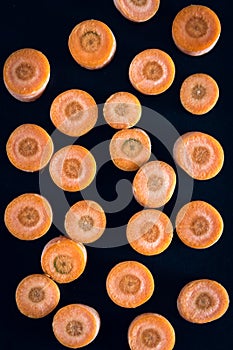 Raw sliced carrot on the black background