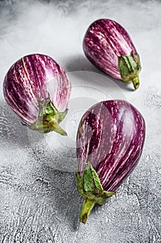 Raw small purple Asian eggplants. White background. Top view