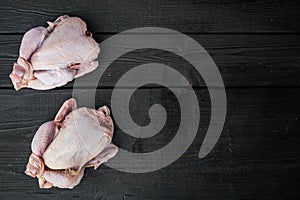 Raw small young chicken, on black wooden background, top view with copy space for text