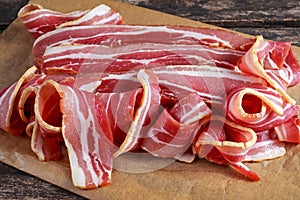 Raw smoked streaky sliced bacon on crumpled paper