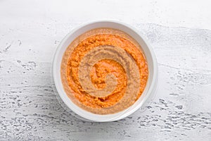 Raw soaked red lentils punched in blender in white bowl on light gray background, top view. Cooking vegan lentil dumplings,