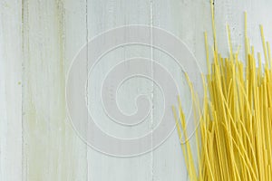 Raw Spaghetti or Pasta on White Wood Background Texture.