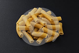 Raw spiral tortiglioni pasta isolated on black background