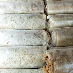 Raw spring rolls placed in plastic boxes by food vendors photo