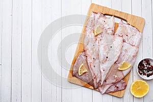 Raw squid carcass with spices and lemon ready for cooking on the table