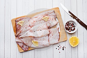 Raw squid carcass with spices and lemon ready for cooking on the table