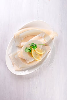 Raw squids and ingredients on the white plate