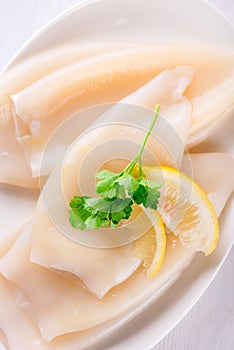 Raw squids and ingredients on the white plate