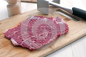 Raw steak piece and meat pounder photo
